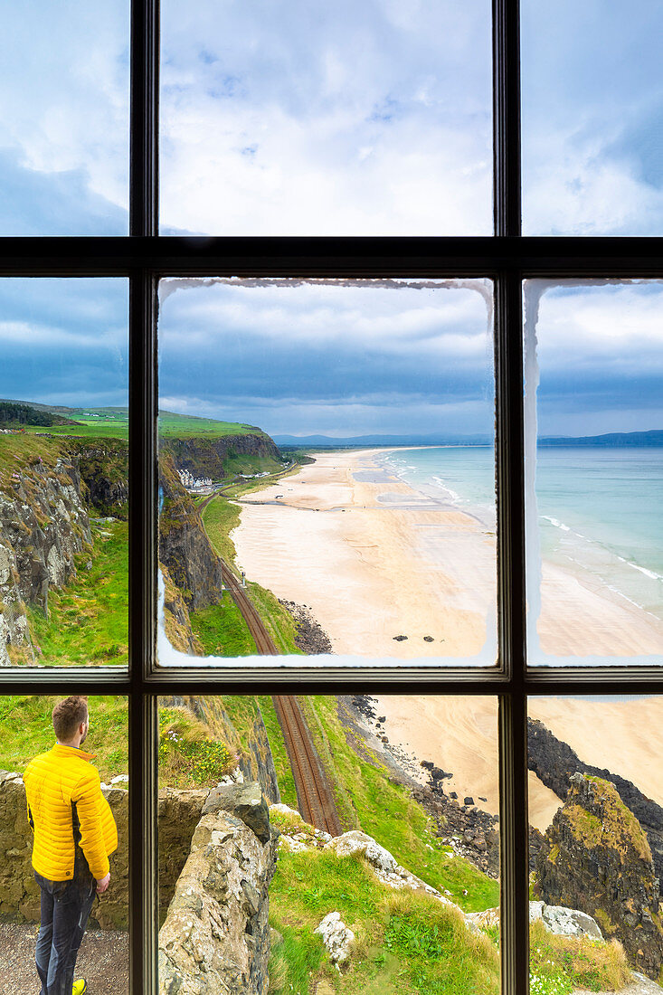 View of a tourist admiring the Downhill beach from inside the Mussenden temple. Castlerock, County Antrim, Ulster region, Northern Ireland, United Kingdom.
