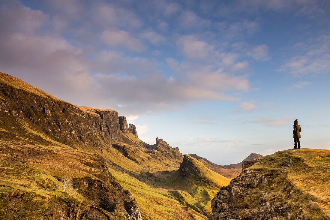 Vereinigtes Königreich, Schottland, Highland, innere Hebriden, Isle of Sky, Halbinsel Trotternish, Frau betrachtet die ikonische Landschaft von Quiraing im Winter