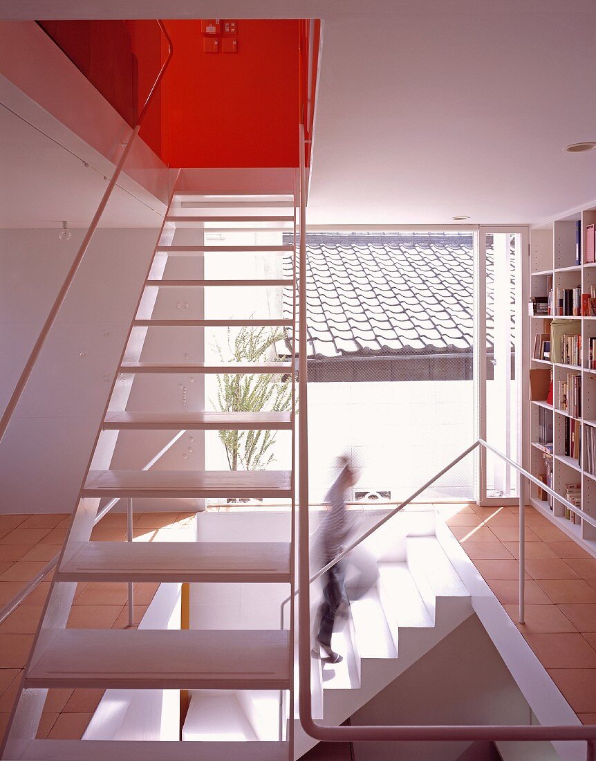 An open stairway with built in bookshelves and floor-to-ceiling windows