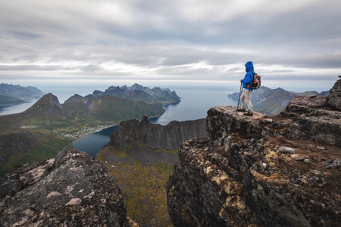 Wanderer auf einem Vorgebirge auf dem Gipfel des Grytetippen über den Fjorden und Bergen der Insel Senja, Norwegen