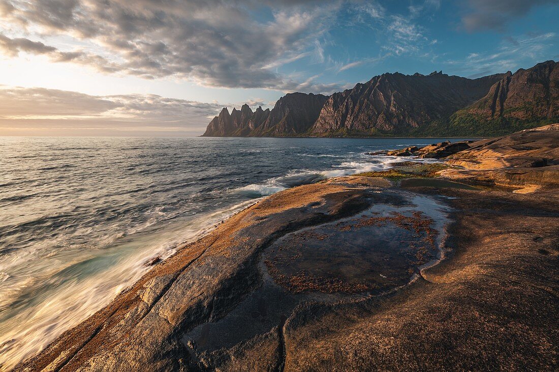 PUDDLE OF SEAWATER AND FJORD AT SUNSET, TUNGENESET, SENJA, NORWAY