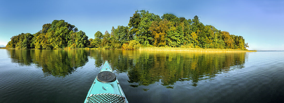 Blick vom Kayak auf den Starnberger See mit Bäumen im Hintergrund, Bayern, Deutschland