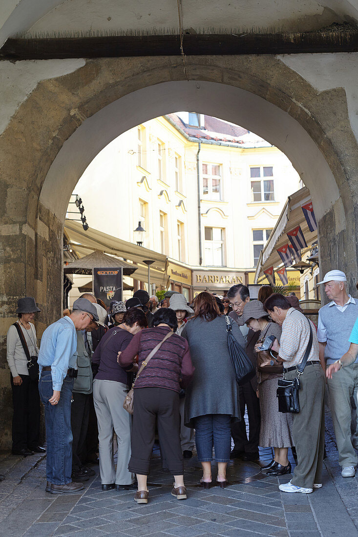 Group of tourists under an archway in downtown Bratislava, Slovakia.