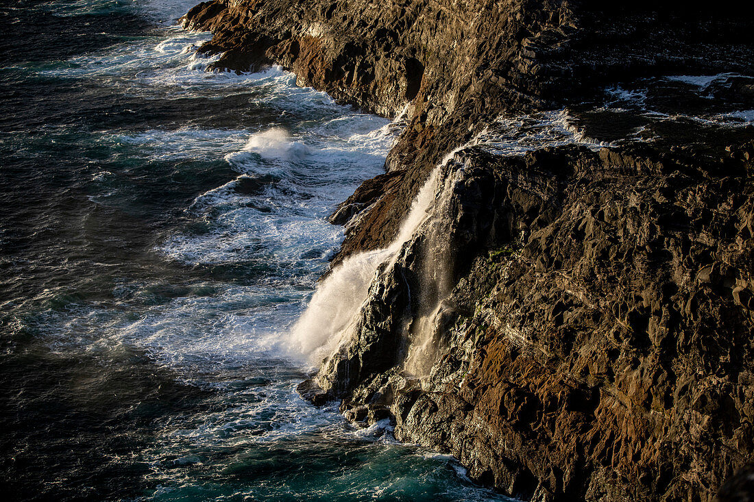 Steep coast in the west of the island of Vágar with the waterfall Bøsdalafossur and the rock needle Geitaskoradrangur near the largest lake in the Faroe Islands, Leitisvatn, Faroe Islands