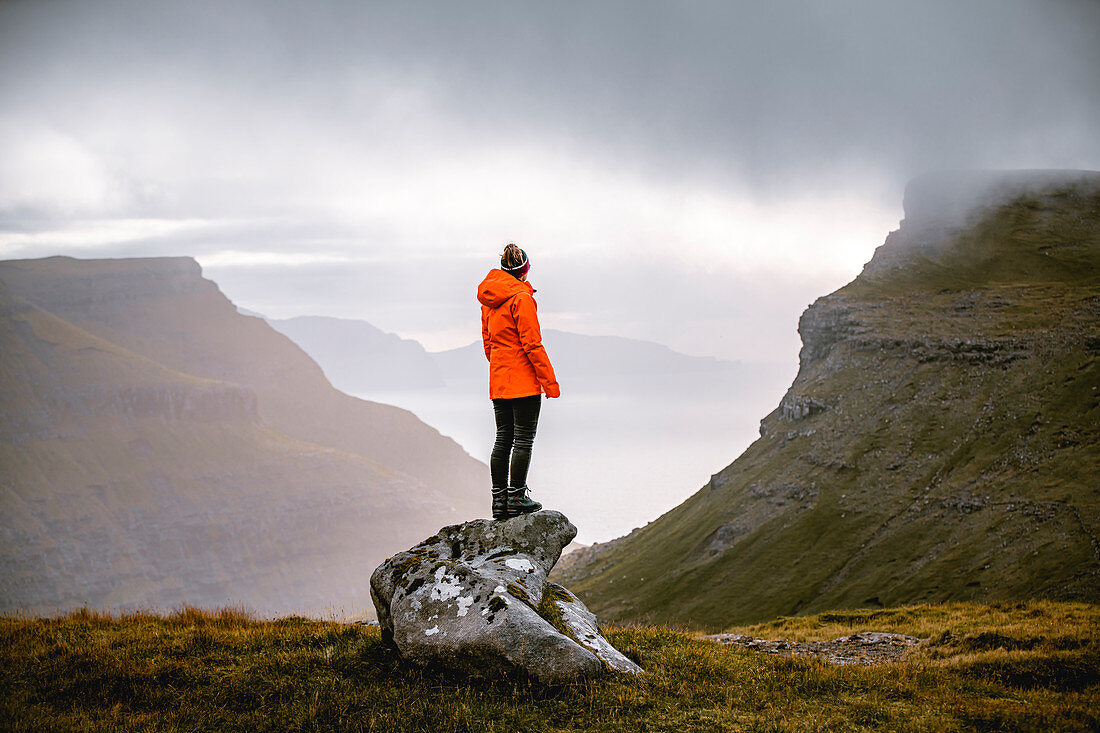 Wandererin genießt den Ausblick auf die herrliche Landschaft der Färöer Inseln