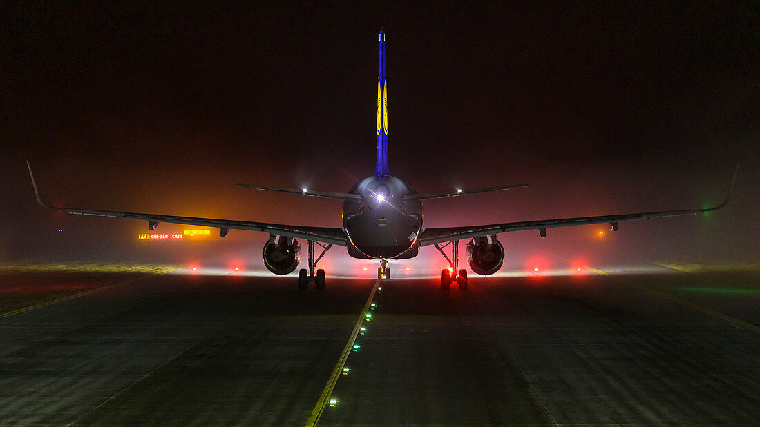 Airbus A320 bei Nacht und Nebel vor der Startbahn am Flughafen München, Bayern, Deutschland