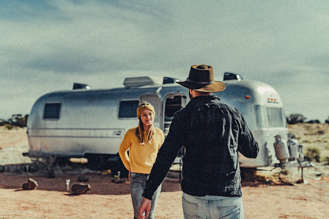 Couple running towards each other in front of Airstream in Flagstaff, Grand Canyon, Arizona, USA, North America