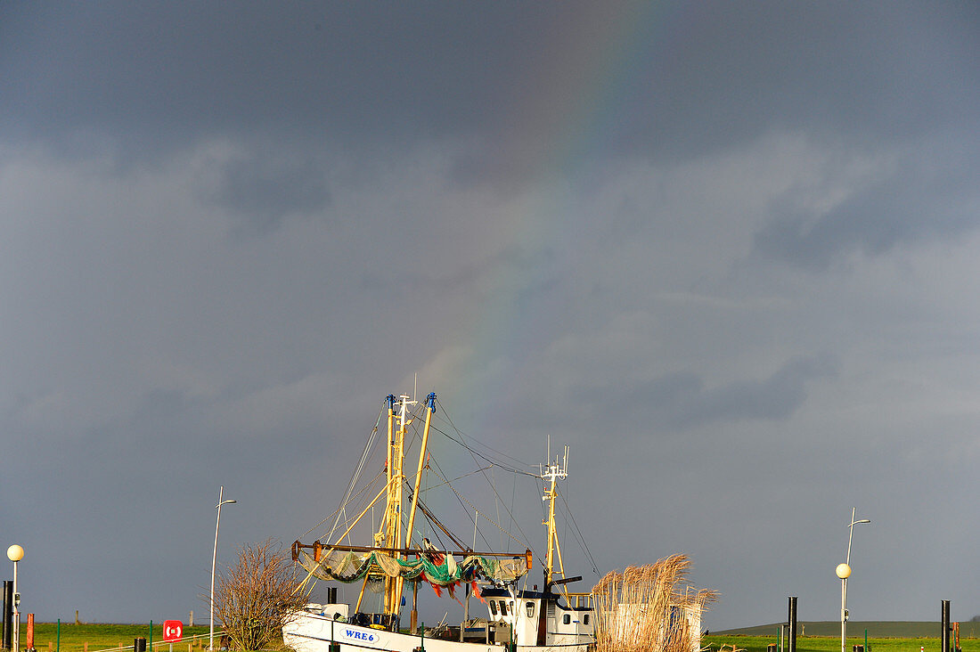 A rainbow behind a fishing cutter on the North Sea, Duhnen, Cuxhaven district, Lower Saxony