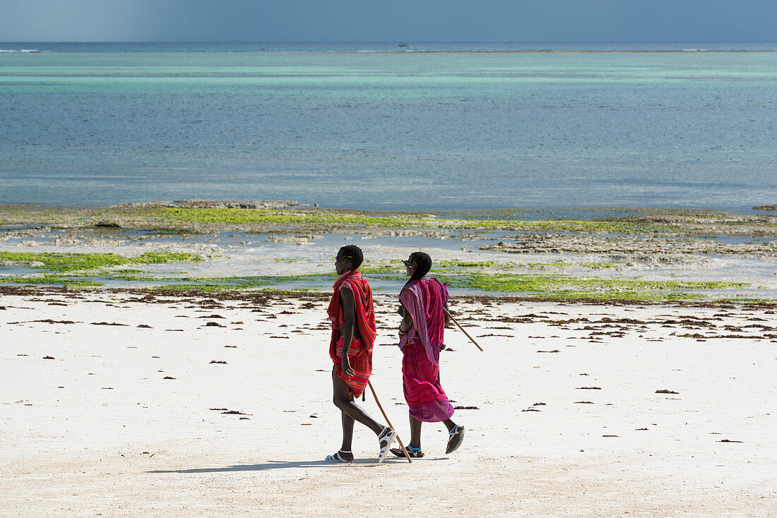 Ostafrika, Tansania, Sansibar, zwei Massai beim Spazierengehen am Kiwengwa-Strand