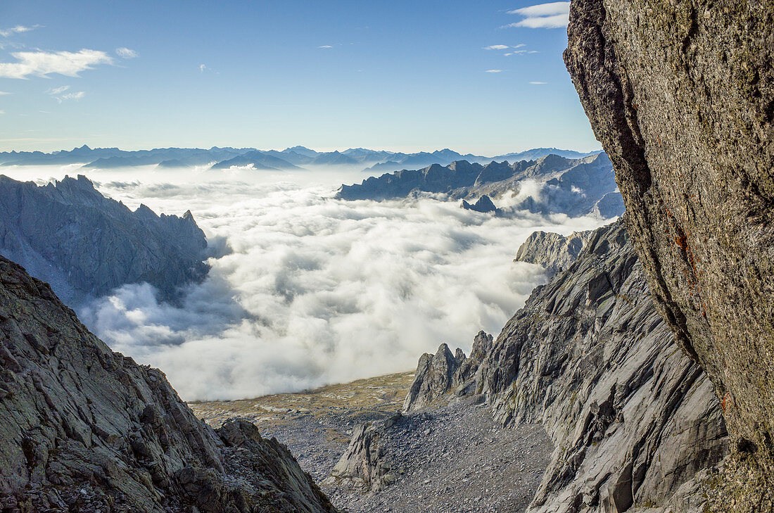 Val Masino in a sea of clouds view from Porcellizzo Pass, Sondrio province, Valtellina, Lombardy, Italy 