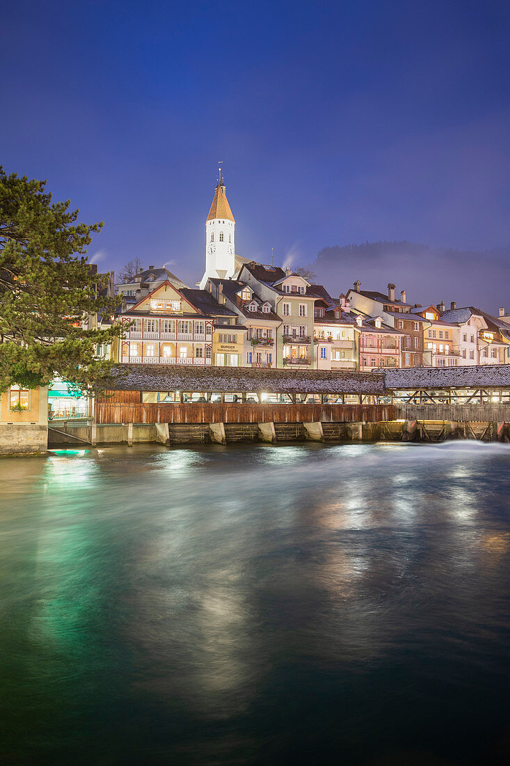 Historical center is reflected in the Aare river at dusk. Thun, Canton of Bern, Switzerland, Europe.