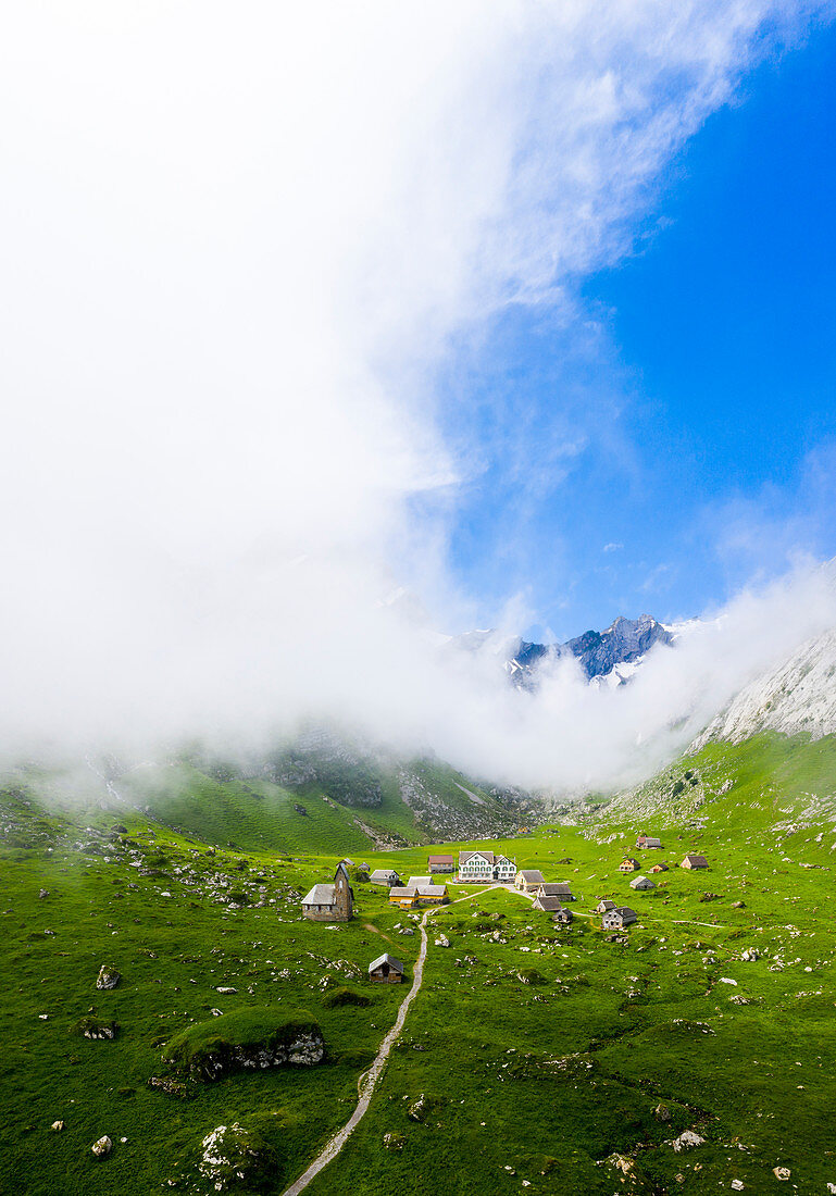 Sunlight filters between fog at the pasture of Meglisalp ,Canton of Appenzell, Alpstein, Switzerland, Europe