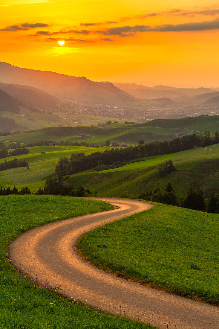 Kurvenreiche Straße über den Hügeln bei Sonnenuntergang, Kanton Appenzell, Alpstein, Schweiz, Europa