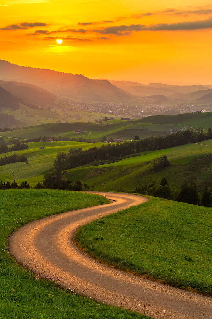 Winding road over the hills at sunset,Canton of Appenzell, Alpstein, Switzerland, Europe