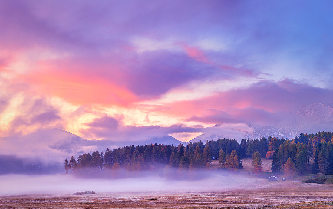 Die Farben des Sonnenaufgangs erhellen den Nebel, Seiser Alm, Dolomiten, Provinz Bozen, Südtirol, Italien, Europa