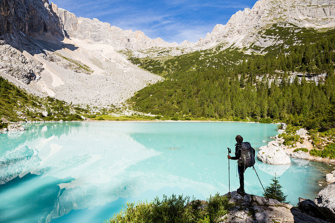 Italy,Veneto,Belluno district,Cortina d'Ampezzo,hiker admires the turquoise water of Lake Sorapis