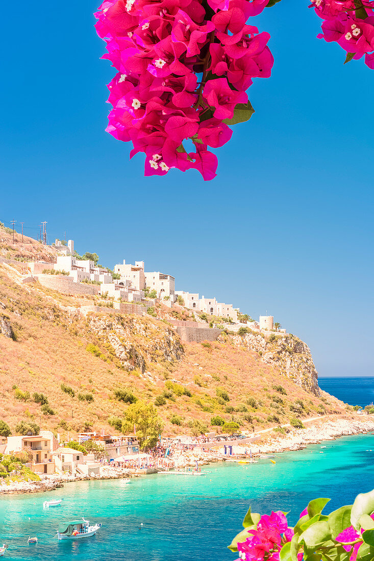 Turquoise sea color at Limeni framed by purple blooming flowers, Mani region, Peloponnese, Greece, Europe