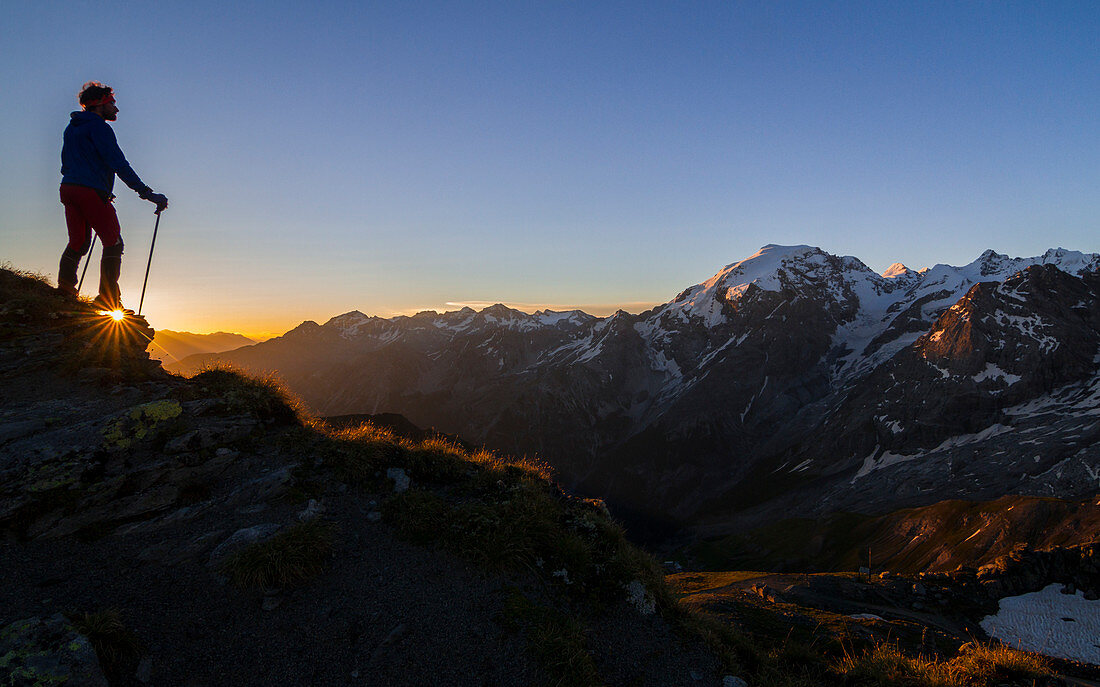 Trekker bei Sonnenaufgang über dem Stilfser Joch (Geibrgspass), Lombardei, Italien