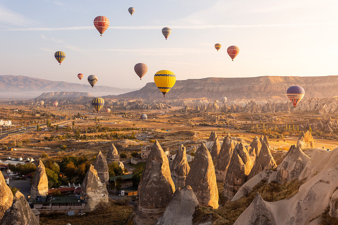 Hot air balloons between the rock tuff formations of Goreme. Capadocia, Kaisery district, Anatolia, Turkey. 