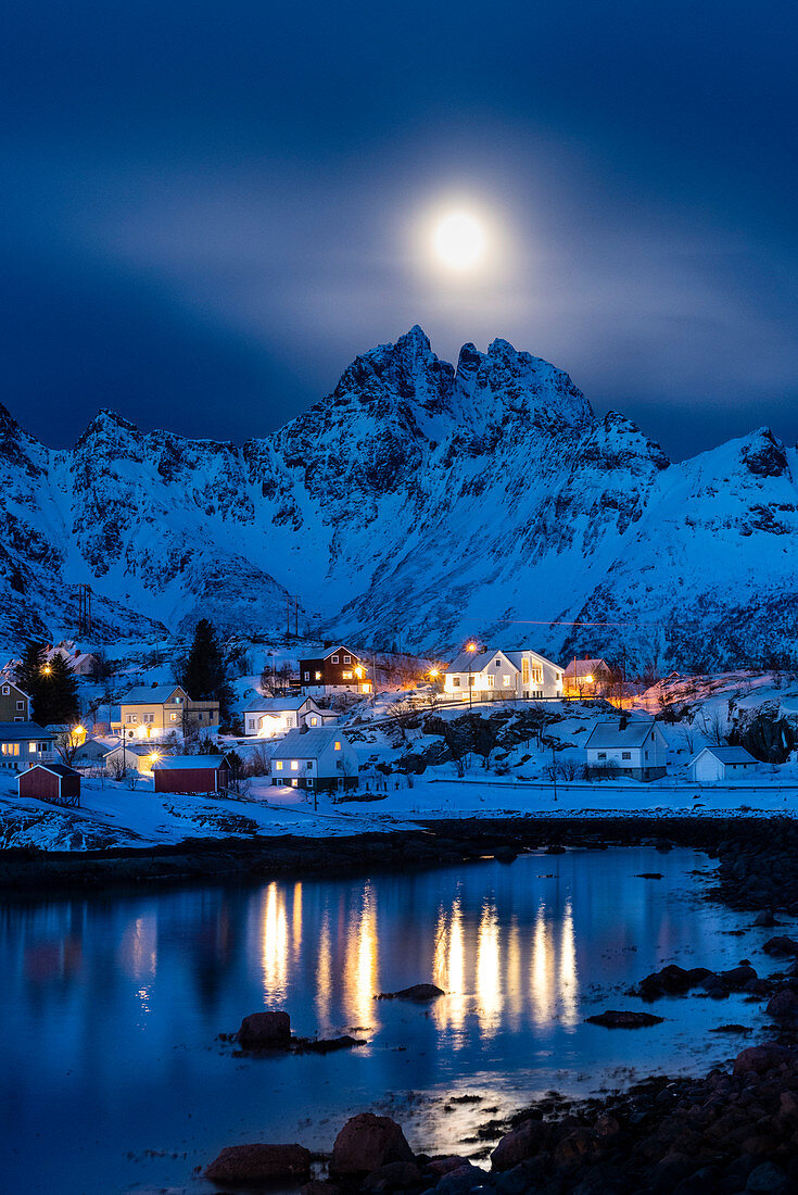 The small village of A, the lasf of Lofoten island by night. With moonlight and mountain peaks in background. A, Lofoten Island, Norway, Scandinavia, Europe.
