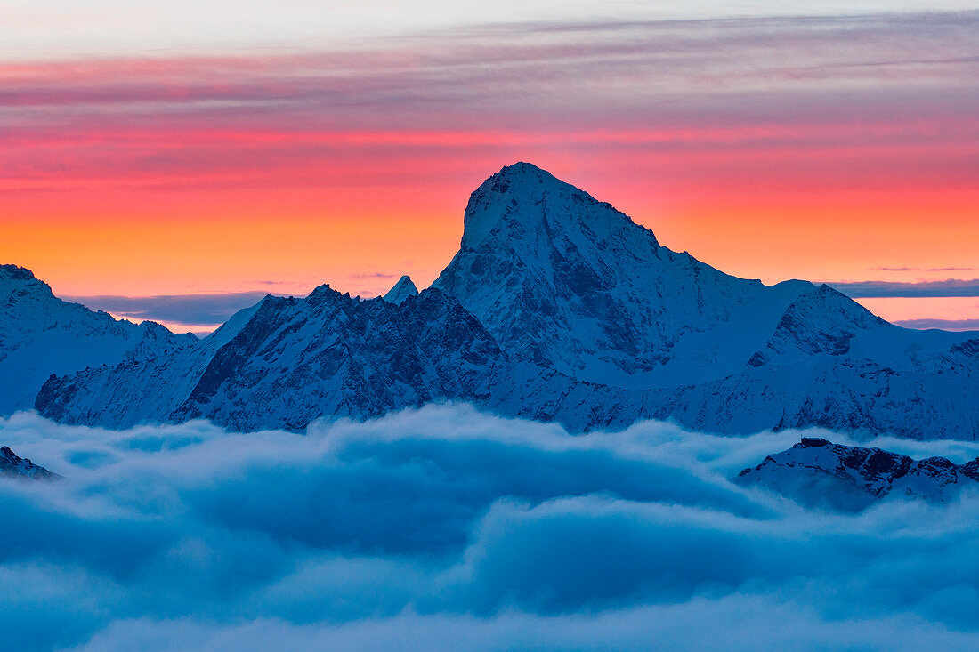 Dent Blanche-Gipfel über Wolken bei Sonnenaufgang im Winter in den Schweizer Alpen, Refuge Igloo des Pantalons Blancs, Heremence, Sion, Kanton Wallis, Schweiz, Europa