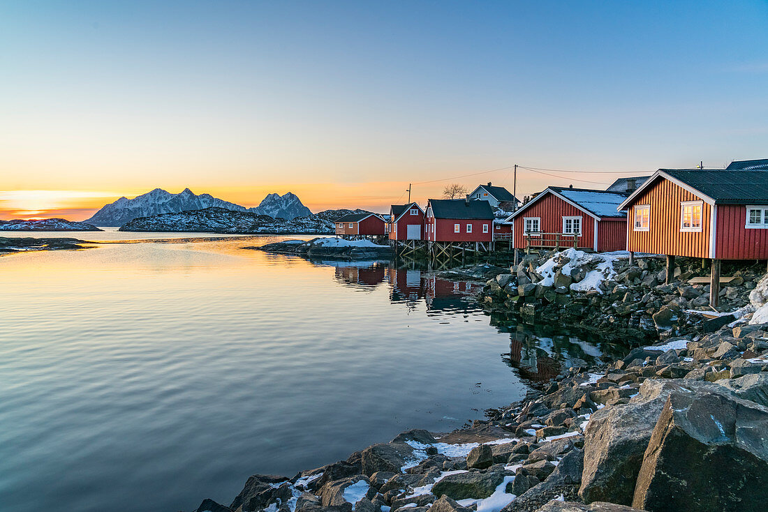 Typische rote Fischerhäuser am Meer im Morgengrauen im Winter, Svolvaer, Nordland, Region Nordnorwegen, Norwegen