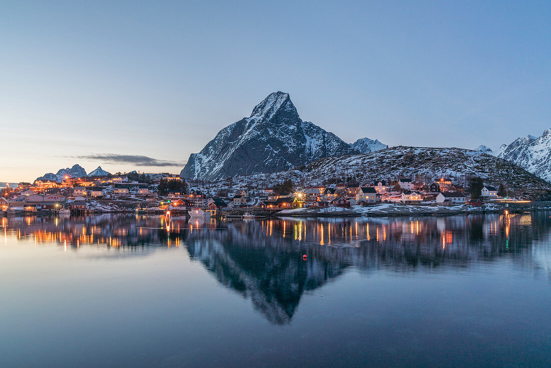 Bucht von Reine in der Abenddämmerung im Winter, mit Olstinden-Gipfel im Hintergrund, Reine, Nordland, Nordnorwegen, Norwegen