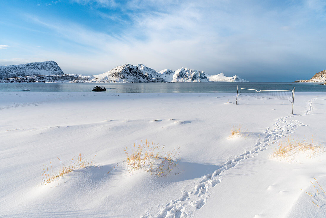Volleyballnetz am Strand von Haukland im Winter, mit Bergen im Hintergrund, Leknes, Nordland, Nordnorwegen, Norwegen