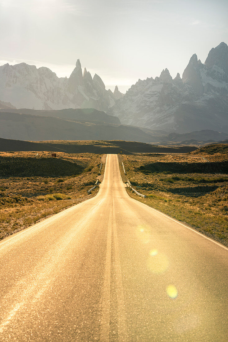 Road leading to El Chalten, with Fitz Roy range in the background at sunset. El Chalten, Santa Cruz province, Argentina.
