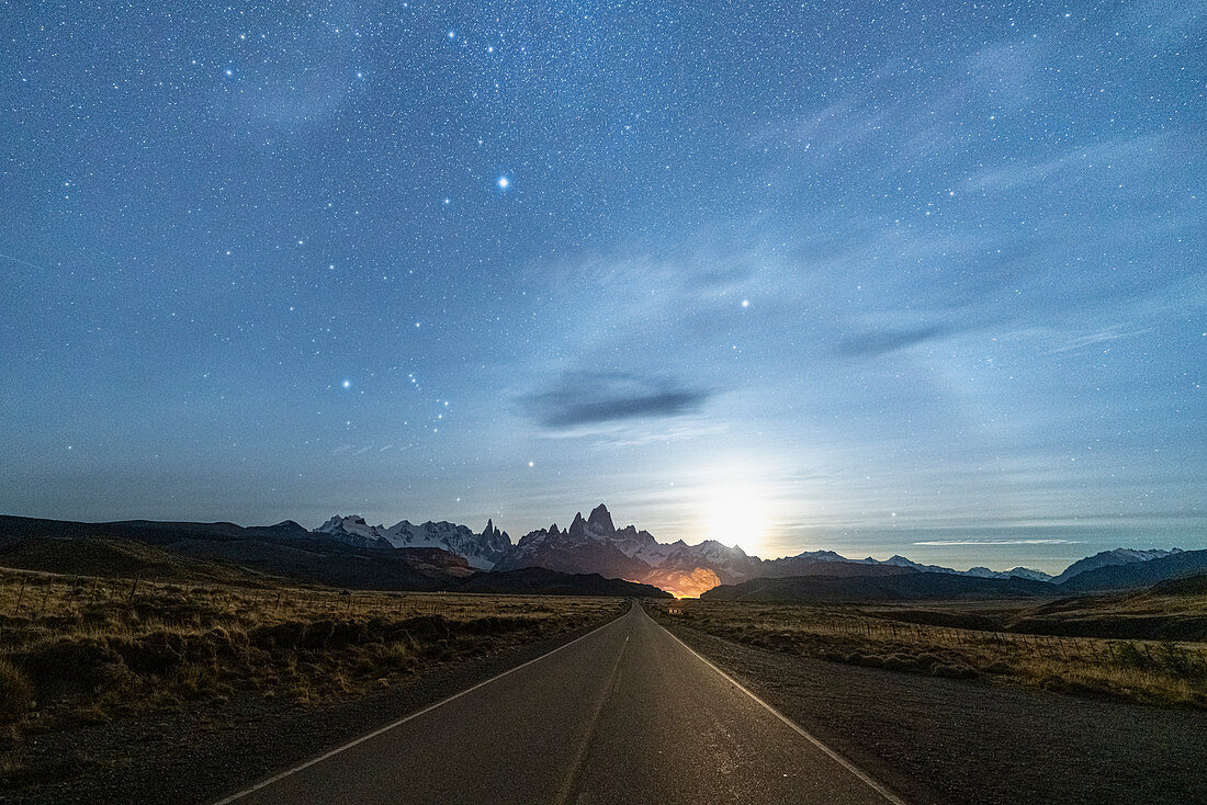 Road leading to El Chalten, with Fitz Roy range and moonlight in the background at night. El Chalten, Santa Cruz province, Argentina.