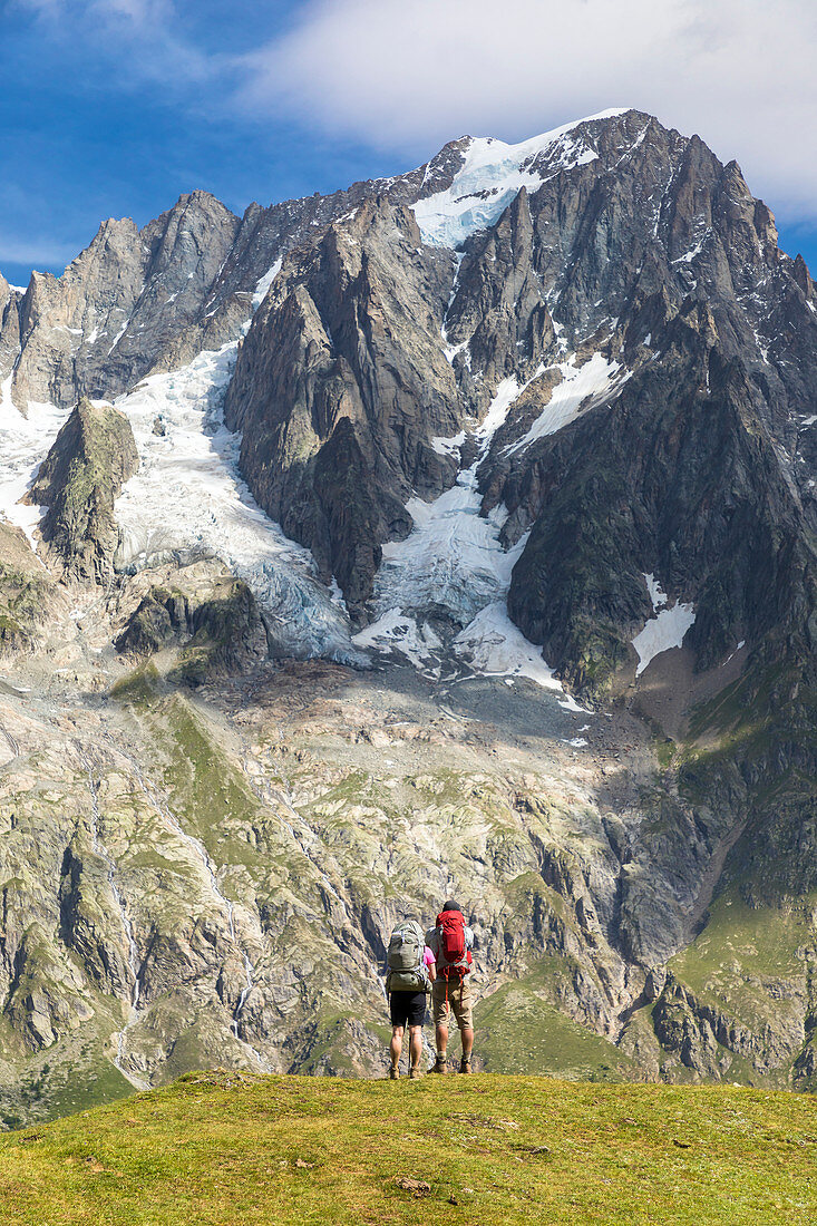 Zwei Wanderer beobachten die Grandes Jorasses während der Mont Blanc-Wandertouren (Frettchen-Tal, Courmayeur, Provinz Aosta, Aostatal, Italien, Europa)