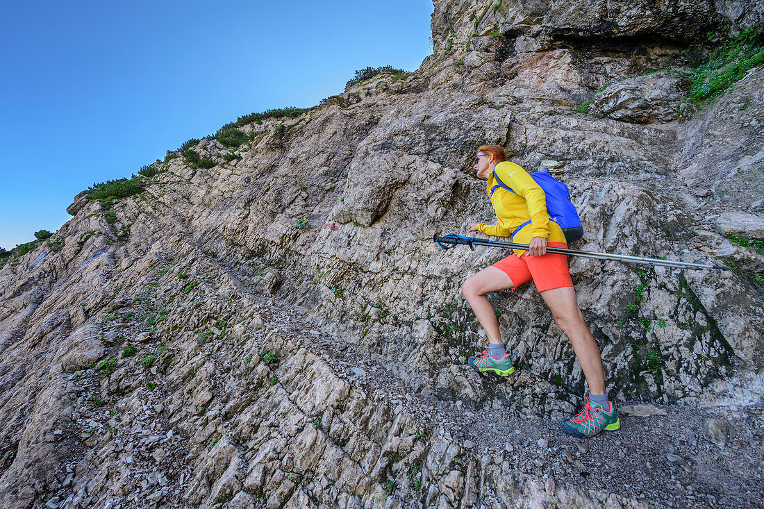 Frau beim Wandern steigt über Felsen zum Sonntagshorn auf, Sonntagshorn, Chiemgauer Alpen, Chiemgau, Oberbayern, Bayern, Deutschland