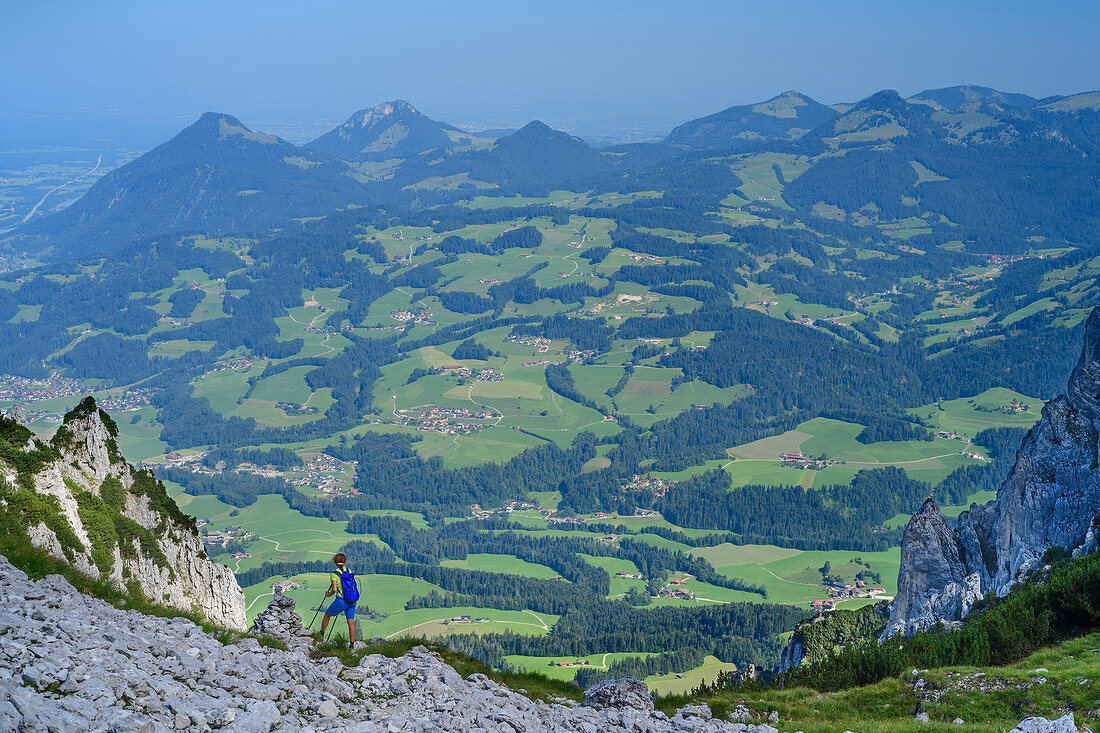 Woman mountaineering descends through the Egersgrinn from the Pyramidenspitze, view of Chiemgau Alps, Pyramidenspitze, Kaiser Mountains, Tyrol, Austria