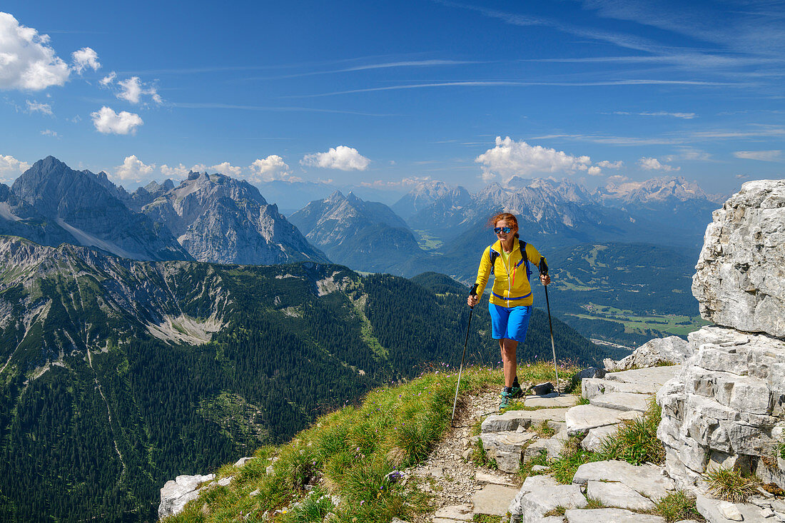 Frau beim Wandern steigt zur Soiernspitze auf, Wörner, Westliche Karwendelspitze, Ahrnspitzen und Wetterstein mit Zugspitze im Hintergrund, Bayern, Deutschland