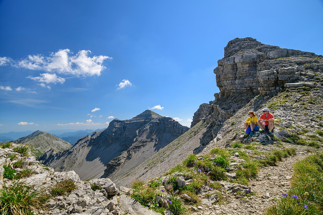 Mann und Frau beim Wandern machen Pause, Soiernspitze im Hintergrund, Karwendel, Oberbayern, Bayern, Deutschland