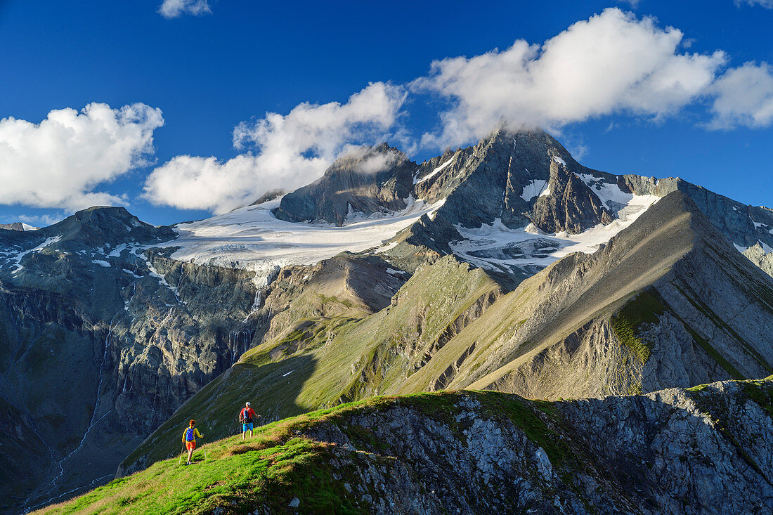 Mann und Frau beim Wandern steigen zum Figerhorn auf, Großglockner im Hintergrund, Glocknergruppe, Nationalpark Hohe Tauern, Osttirol, Österreich