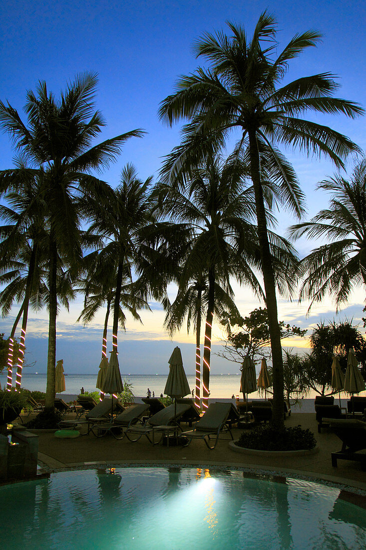 Thailand, Phuket, Kata Noi Strand, Sonnenuntergang am Pool, Palmen und Menschen