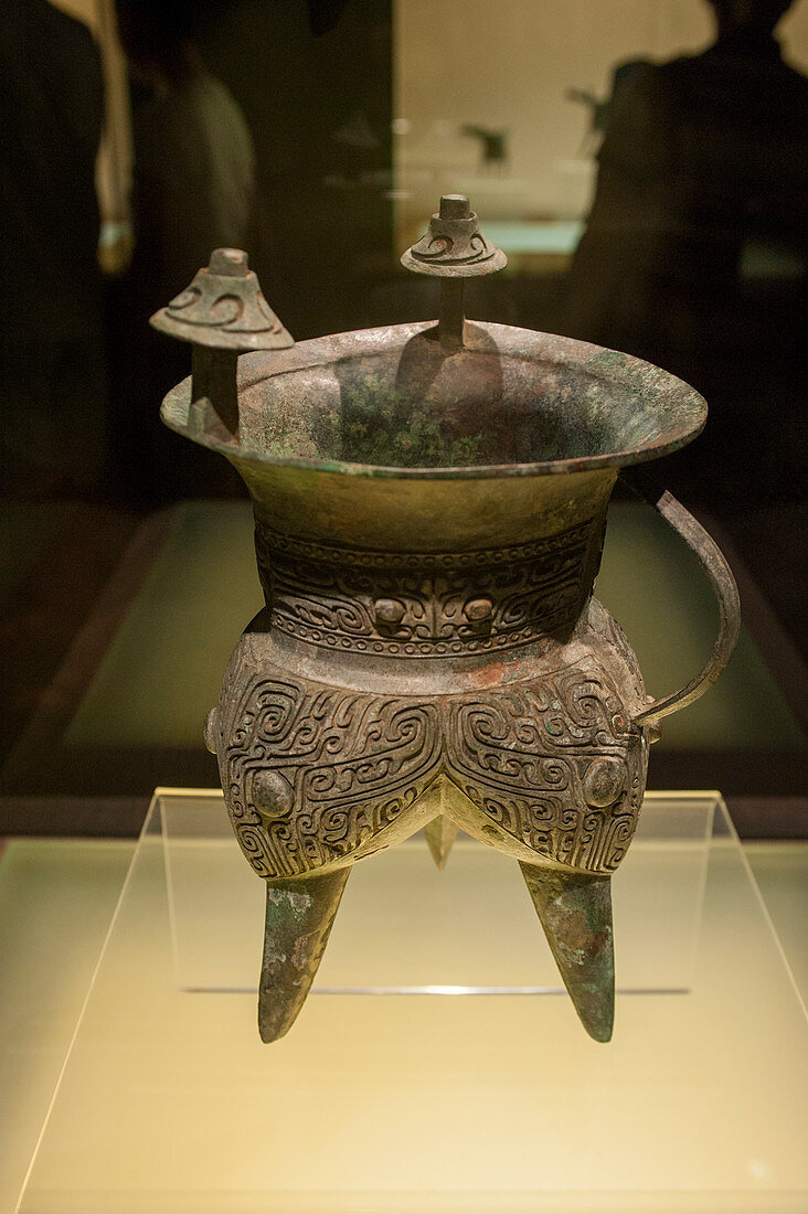 Ein Weingefäß aus dem 16. bis 13. Jahrhundert v. Chr. in der Bronzeausstellung im Shanghai Museum, einem Museum für altchinesische Kunst, auf dem People's Square im Bezirk Huangpu in Shanghai, China.