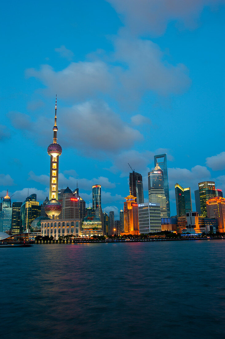 Blick vom Bund bei Nacht auf den Huangpu-Fluss, das 492 Meter hohe World Financial Center und den Oriental Pearl-Fernsehturm in Pudong, Shanghai, China.