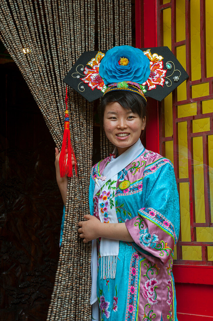 Eine Kellnerin in einem historischen Kostüm im Bai Jia Da Yuan Restaurant in Peking, China.