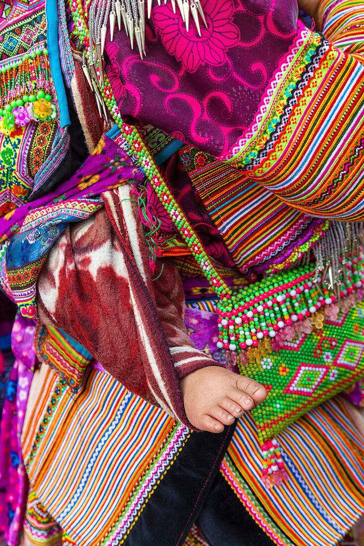 Flower Hmong tribes baby on mothers back. Bac Ha market, Lao Cai province, Vietnam.