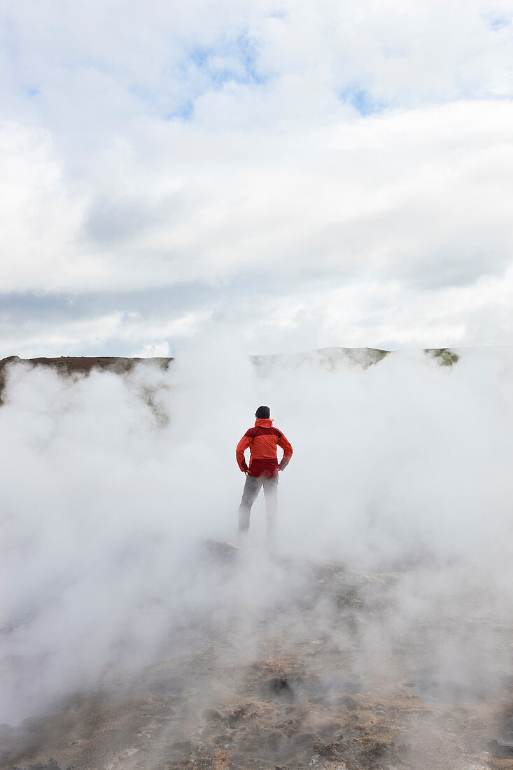 Frau steht an geothermischen Pools, Island