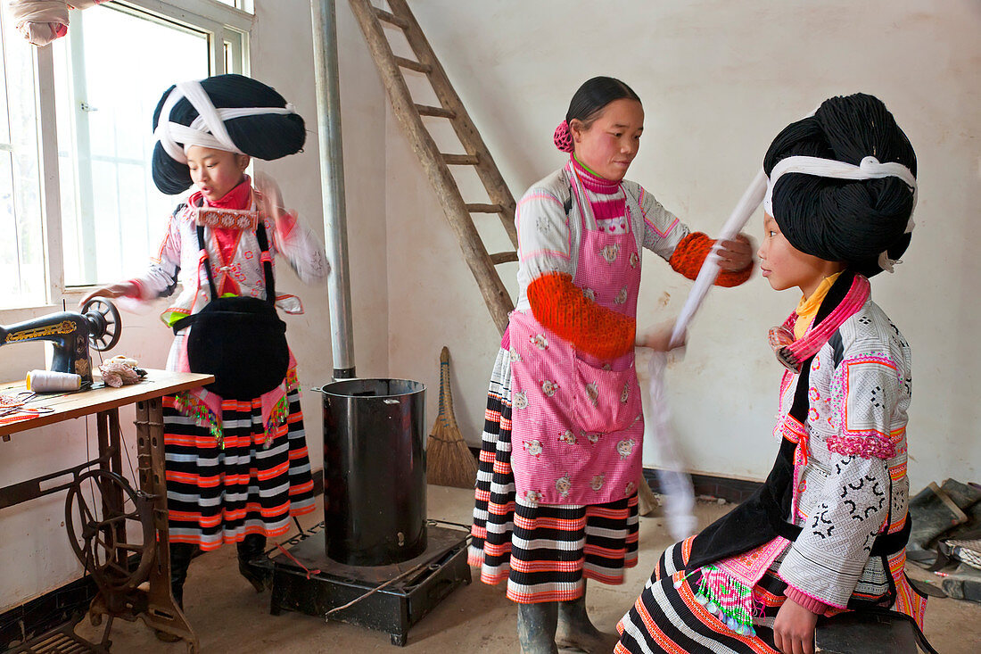 Langhorn Miao Frau bereitet den Kopfschmuck eines Mädchens vor, Sugao, China