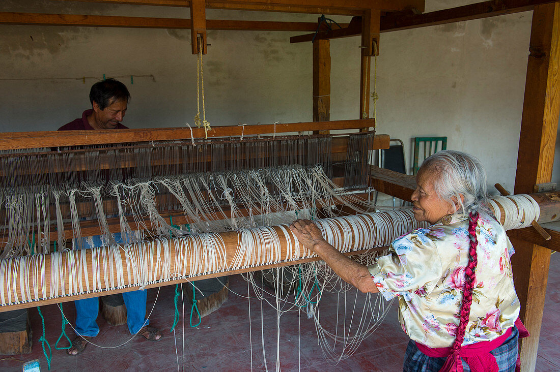Eine alte Zapotek-Frau bereitet einen Webstuhl für das Weben eines Teppichs in einem Heimstudio für Weber in Teotitlan del Valle vor, einer kleinen Stadt in der Region Valles Centrales in der Nähe von Oaxaca im Süden Mexikos.
