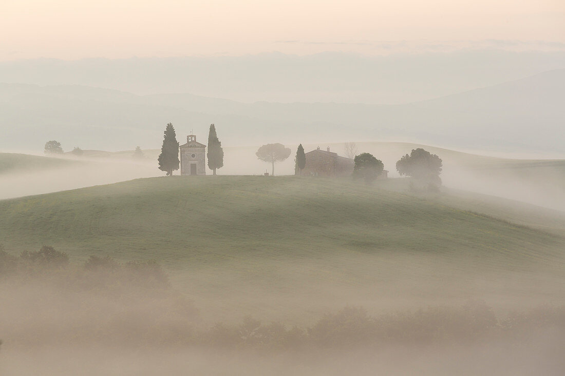 Chapel in morning mist in Tuscany Italy