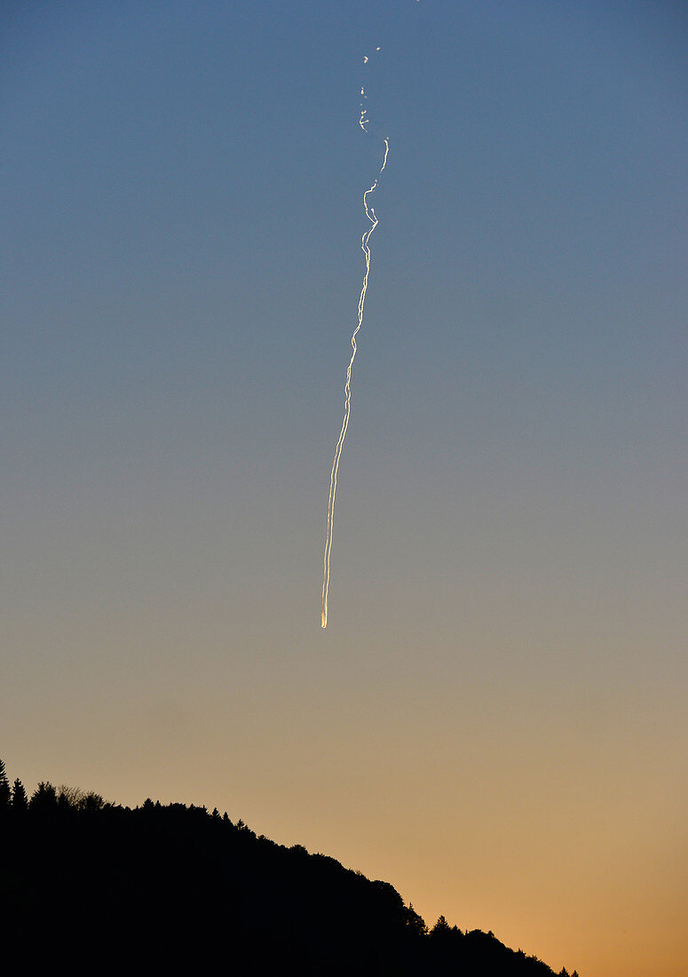 Airplane over a mountain at dusk with contrails, near Ybbs, Danube, Austria