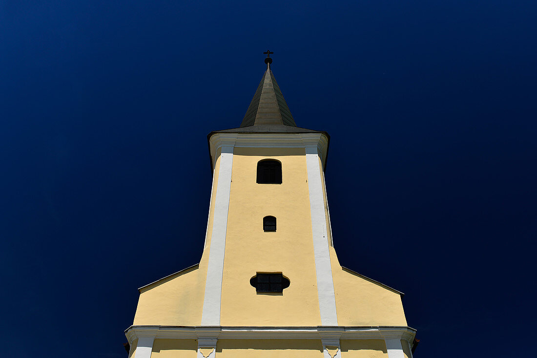 Yellow and white church against a deep blue sky in Strmec, Croatia