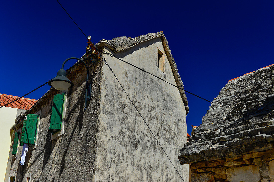 Sehr altes Haus mit Steindach vor einem tiefblauen Himmel, Primosten, Dalmatien, Kroatien