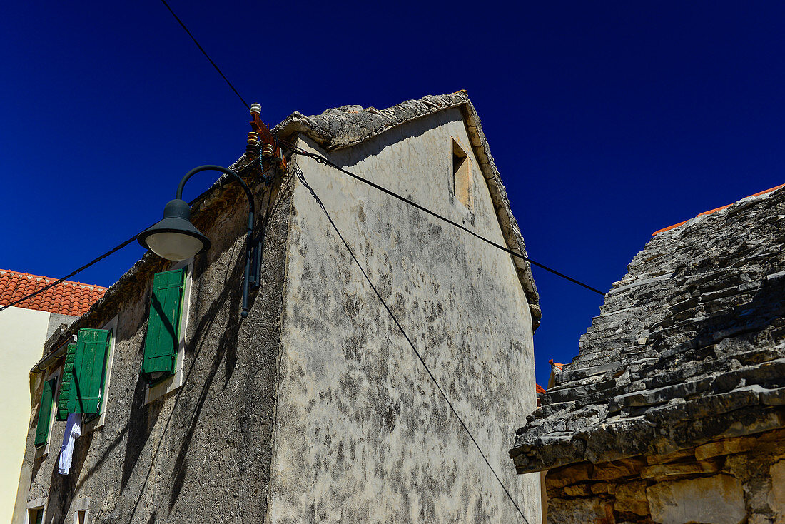 Very old house with a stone roof in front of a deep blue sky, Primosten, Dalmatia, Croatia