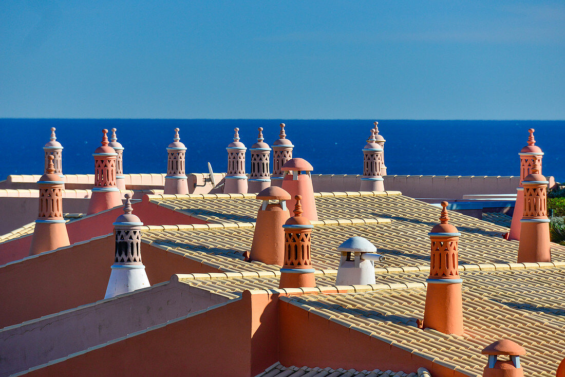 Rote Dächer mit Schornsteinen vor dem blauen Atlantik, Luz, Algarve, Portugal